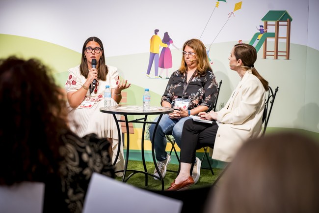 Mesa de coloquio con tres mujeres sentadas alrededor