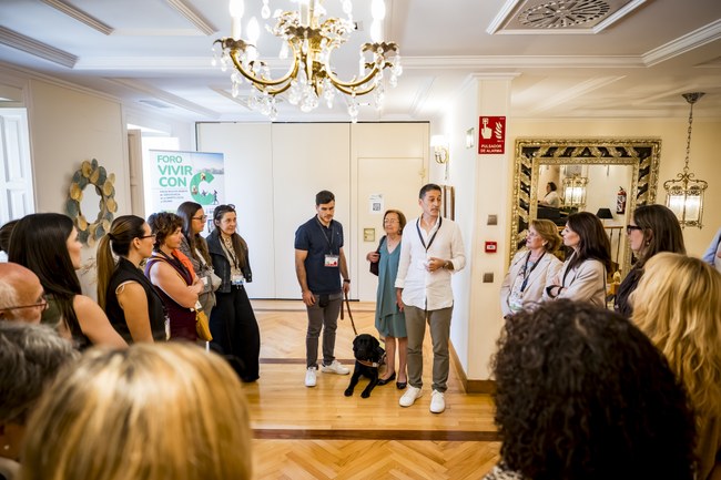 Varias personas y perro guía entrando en la sala