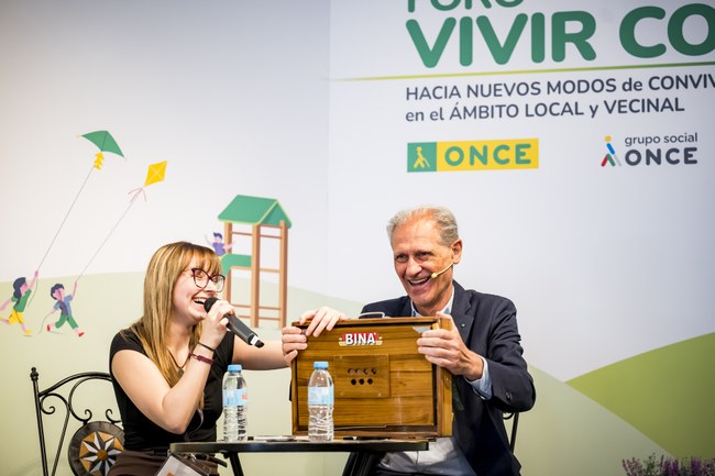 Presentador y premiada en escenario abriendo un cofre