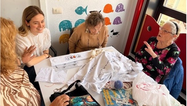 Varias personas alrededor de una mesa de costuras y manualidades, imagen de proyecto finalista