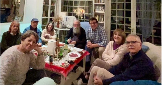 Un grupo de personas alrededor de una mesa con comida dentro de un salón, imagen de proyecto finalista