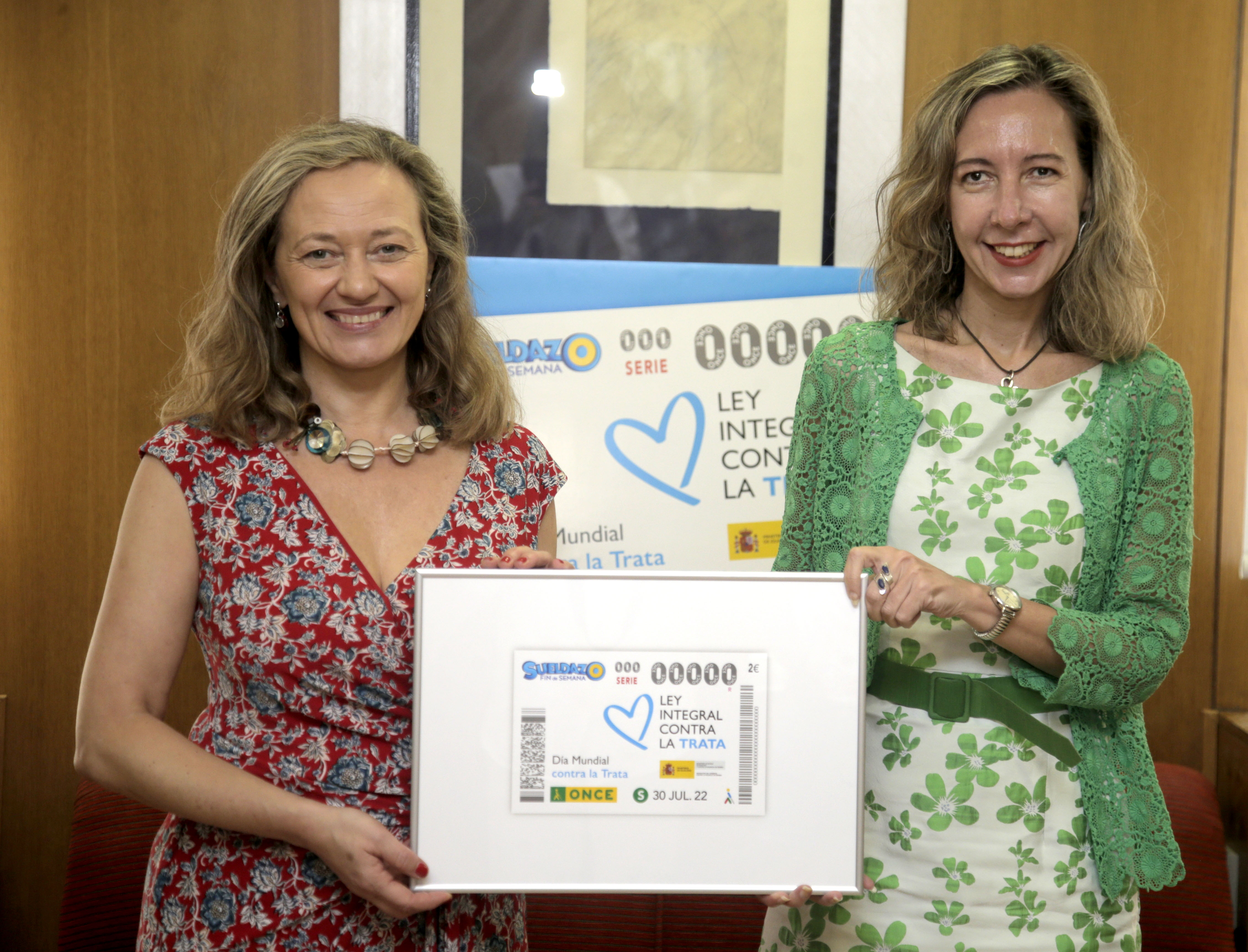 Victoria Rosell y Patricia Sanz, con una lámina enmarcada de este cupón