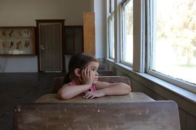 Niña sentada en un pupitre de un colegio