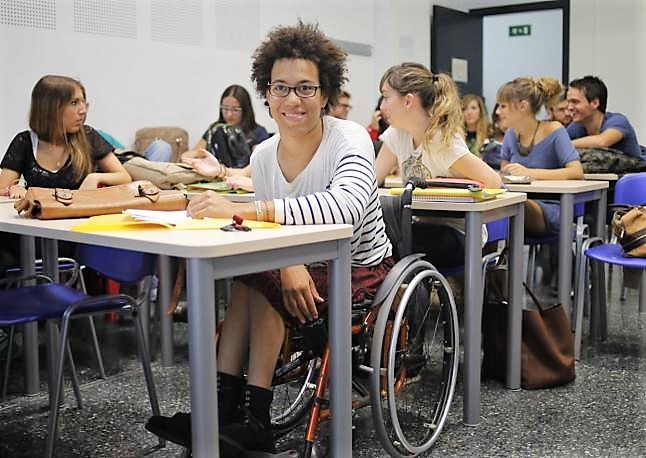 Joven con discapacidad en silla de ruedas en un aula