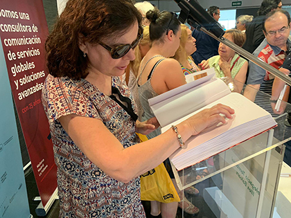 Una mujer ciega lee el Llibre del variat mallorquí editado en Braille