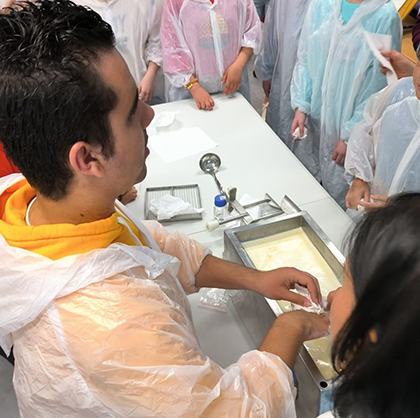 Un joven ciego elabora queso, durante el taller