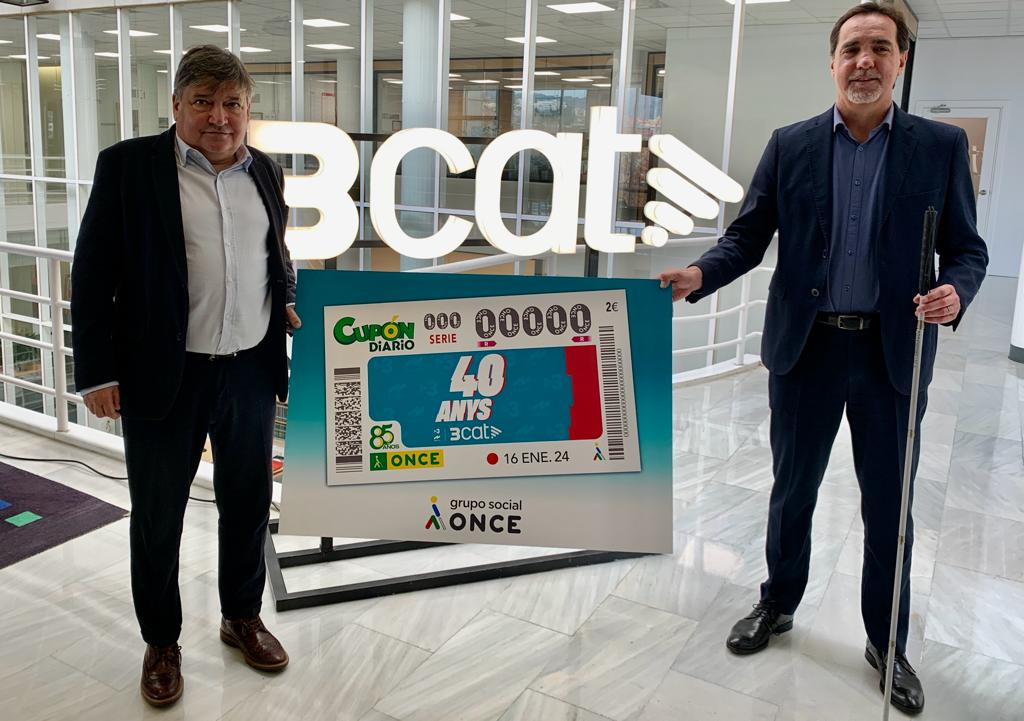 Sigfrid Gras y Enric Botí sostienen una copia gigante del cupón que celebra el 40 aniversario de TV3 y Catalunya Ràdio