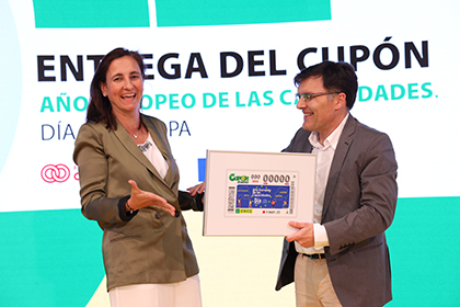 María Andrés recibe, de manos de Alberto Durán, una lámina enmarcada con la imagen de este cupón