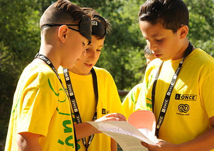 Tres jóvenes estudiantes trabajan juntos en el concurso escolar del Grupo Social ONCE