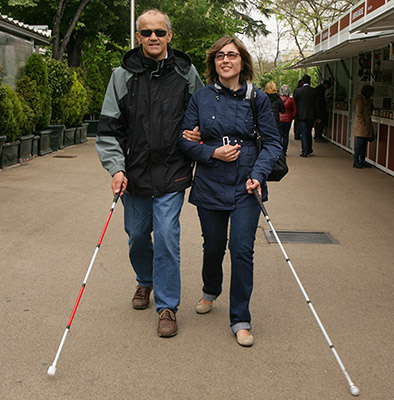 Dos personas con bastón paseando por Madrid