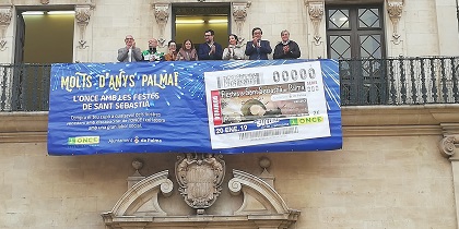 Un balcón del Ayuntamiento de Palma luce una lona que anuncia que la ONCE dedica un cupón a las Fiestas de San Sebastián