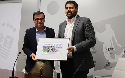 Miguel Ángel Gallardo, alcalde de Villanueva de la Serena, y Fernando Iglesias, delegado territorial de la ONCE en Extremadura, con una copia del cupón