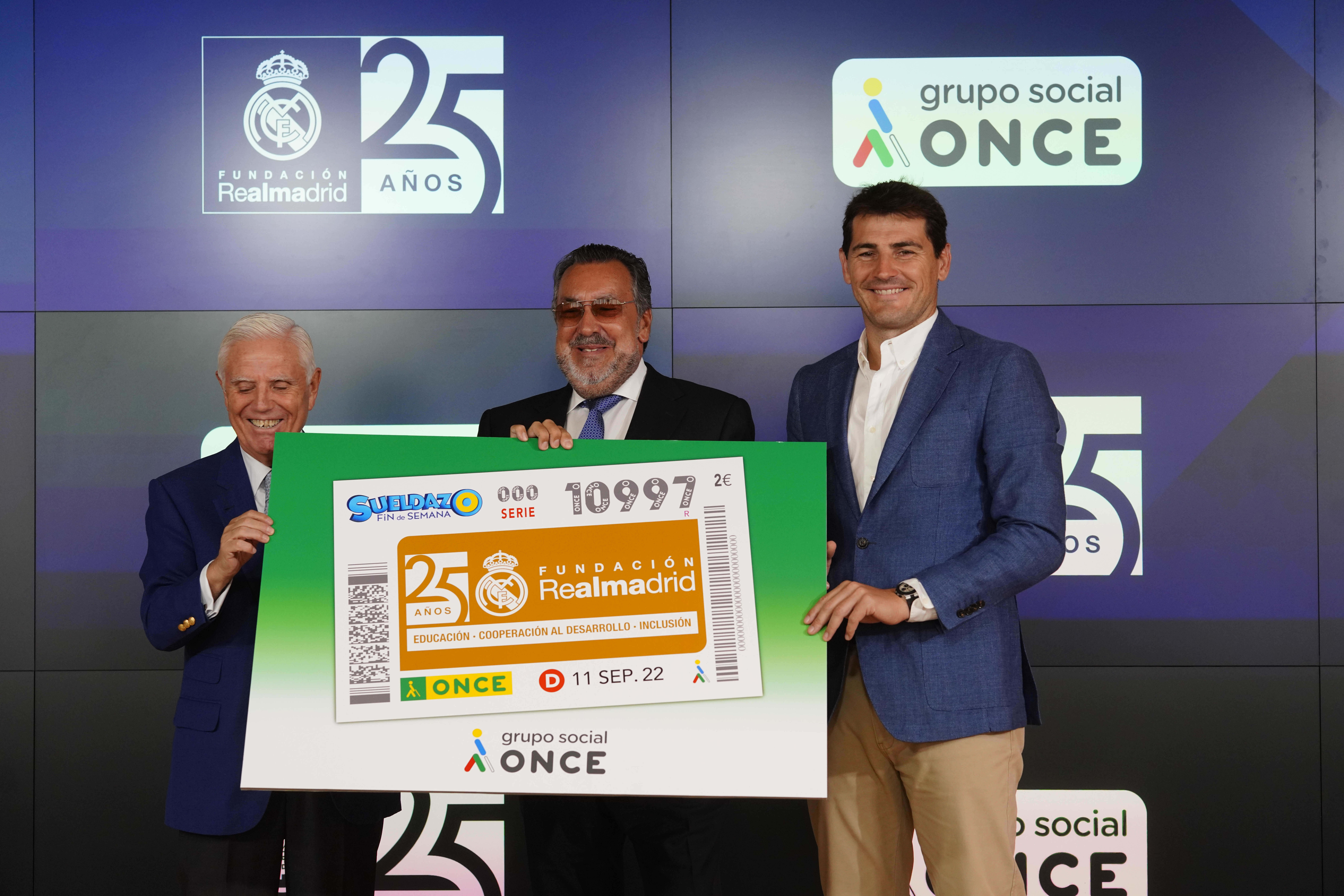 Miguel Carballeda, Iker Casillas y Enrique Sánchez, vicepresidente ejecutivo Fundación Real Madrid posan con el cupón dedicado 