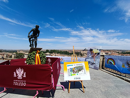 Un cupón de la ONCE gigante, junto a la escultura en homenaje a Bahamontes