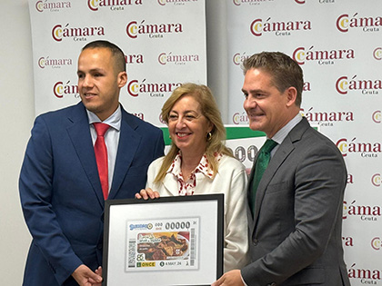 Azman Abdalahe, Adela Nieto y Karim Bulaix, con una lámina enmarcada de este cupón