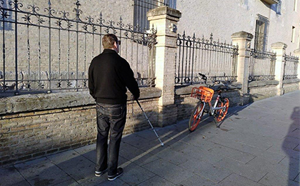 Una persona ciega encuentra en su camino una bici estacionada en la acera