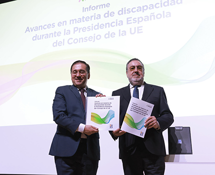 José Manuel Albares y Miguel Carballeda posan con el informe en tinta y braille