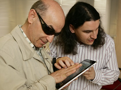 Dos afiliados interactúan con un dispositivo móvil.