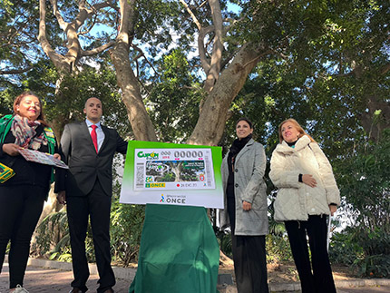 Foto de familia con la imagen del cupón junto al árbol