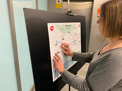 Una joven ciega toca el mapa del Metro de Barcelona accesible, durante la presentación