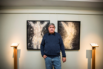 XavierE, entre dos de los cuadros que expone en el Museo Tiflológico de la ONCE