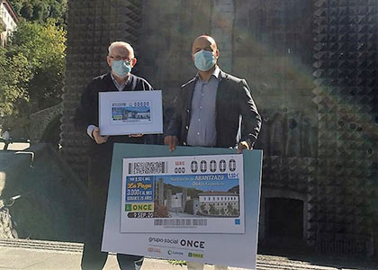 El guardián superior de la orden Franciscana  del santuario de Arantzazu, Juan Ignacio Larrea, y el director  de la ONCE en Donostia / San Sebastián, Roberto Doval, posan junto a la imagen del cupón