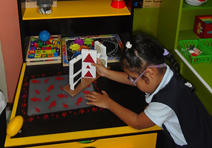 Niña ciega tocando libros con relieve