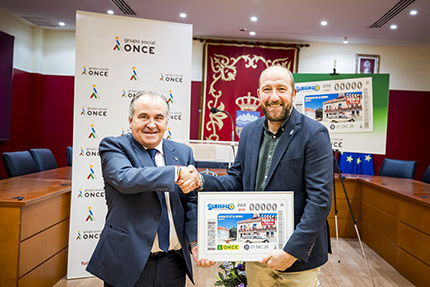 Luis Natalio Royo, delegado de la ONCE en Madrid, y Borja Álvarez, alcalde de Guadalix de la Sierra, sujetan una lámina con la imagen del cupón 
