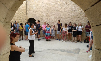 Los estudiantes atienden la explicación de los guías dentro del castillo