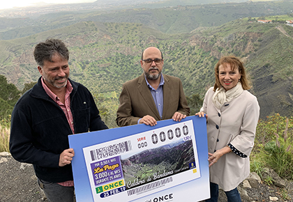 Miguel Ángel Rodríguez Sosa, José Antonio López Mármol e Inés Jiménez Martín, con una copia del cupón dedicado a la Caldera de Bandama, en el borde de dicha caldera