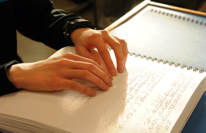 Manos leyendo un libro en Braille