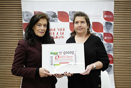 Mónica López Barahona y Bárbara Palau sostienen una lámina enmarcada con este cupón