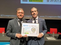 Javier Martínez y Marcelo Rosado sostienen una lámina enmarcada con este cupón