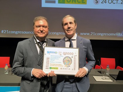 Javier Martínez y Marcelo Rosado sostienen una lámina enmarcada con este cupón