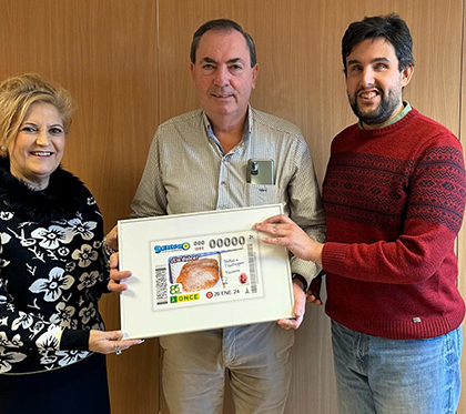 Pilar Herrero, Enrique Munarriz y Ramón Estévez, con una lámina enmarcada de este cupón