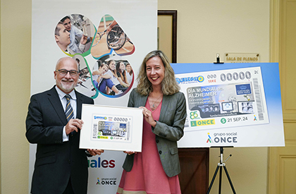 José Luis Nogueira y Patricia Sanz sostienen una lámina enmarcada con este cupón