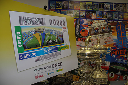 Imagen del cupón de la ONCE junto a trofeos y fotografías del Cádiz CF