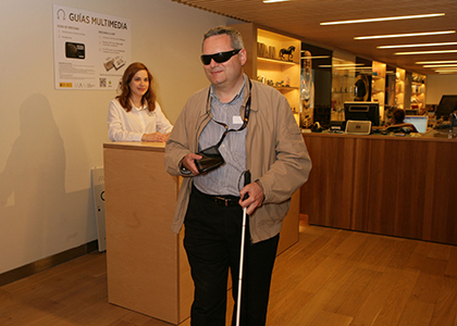 Una persona ciega utiliza una audioguía