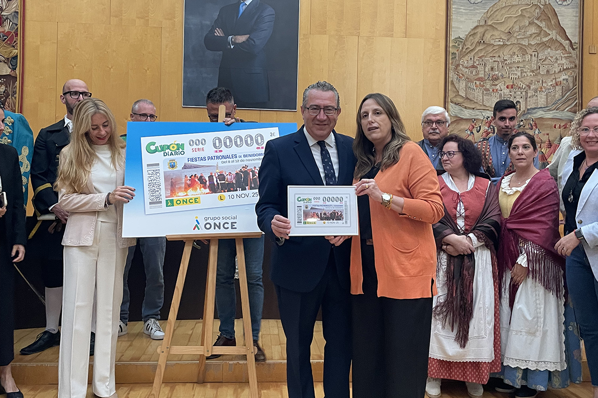 Estela Medina, directora de la ONCE en Alicante y Antonio Pérez, alcalde de Benidorm sosteniendo lámina enmarcada del cupón