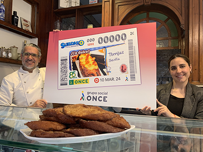 Manu Jara y María Martínez, con una copia gigante de este cupón, tras un plato de torrijas