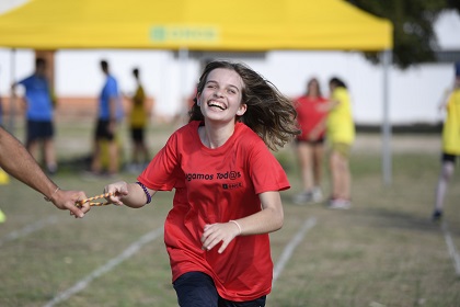Una niña participante llega a meta mostrando una gran alegría