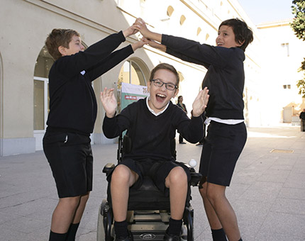 Alumno en silla de ruedas jugando en el patio con sus compañeros