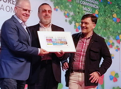 Miguel Carballeda, en el centro de la imagen, entrega a Pere Granados, una lámina con el cupón dedicado a Salou, junto a Alberto Durán