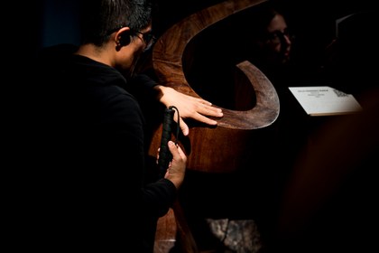 Una persona ciega toca una de las esculturas de la exposición del Tiflológico