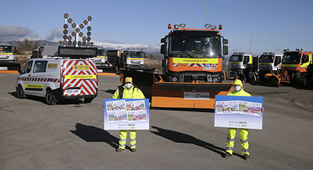 Dos miembros del equipo de conservación de carreteras de la DGT con las láminas de los cupones